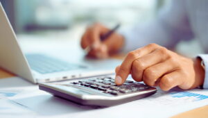 Isinet Consulting Calcolo dell'ammortamento e iperammortamento con calcolatrice e laptop in un ambiente professionale.