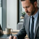 Isinet Consulting Professionista che scrive al computer, mentre esplora come scegliere il bando giusto per la tua impresa — guida pratica.