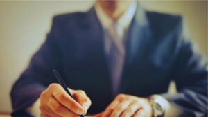 Isinet Consulting Un professionista in giacca e cravatta firma un documento, in linea con il Codice degli Incentivi 2026 e Bando-Tipo MIMIT: cosa cambia per le imprese.